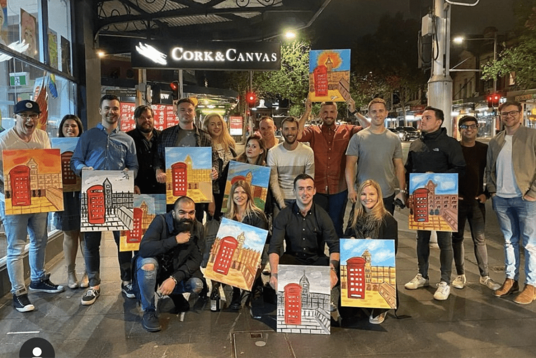 The Sydney team each holding their own paintings of of the Doctor Who red phone booth