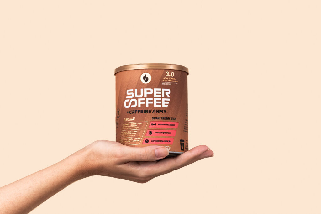 A hand holding a can of Caffeine Army Super Coffee on a neutral background